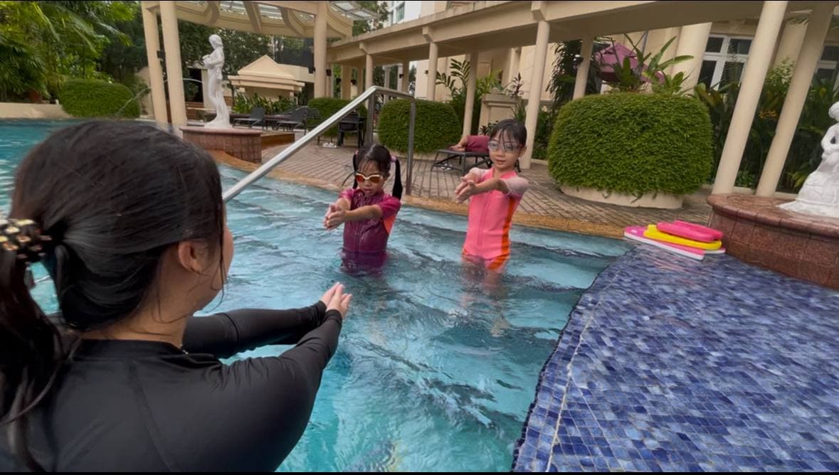 Swimming instructor teaching children in the pool
